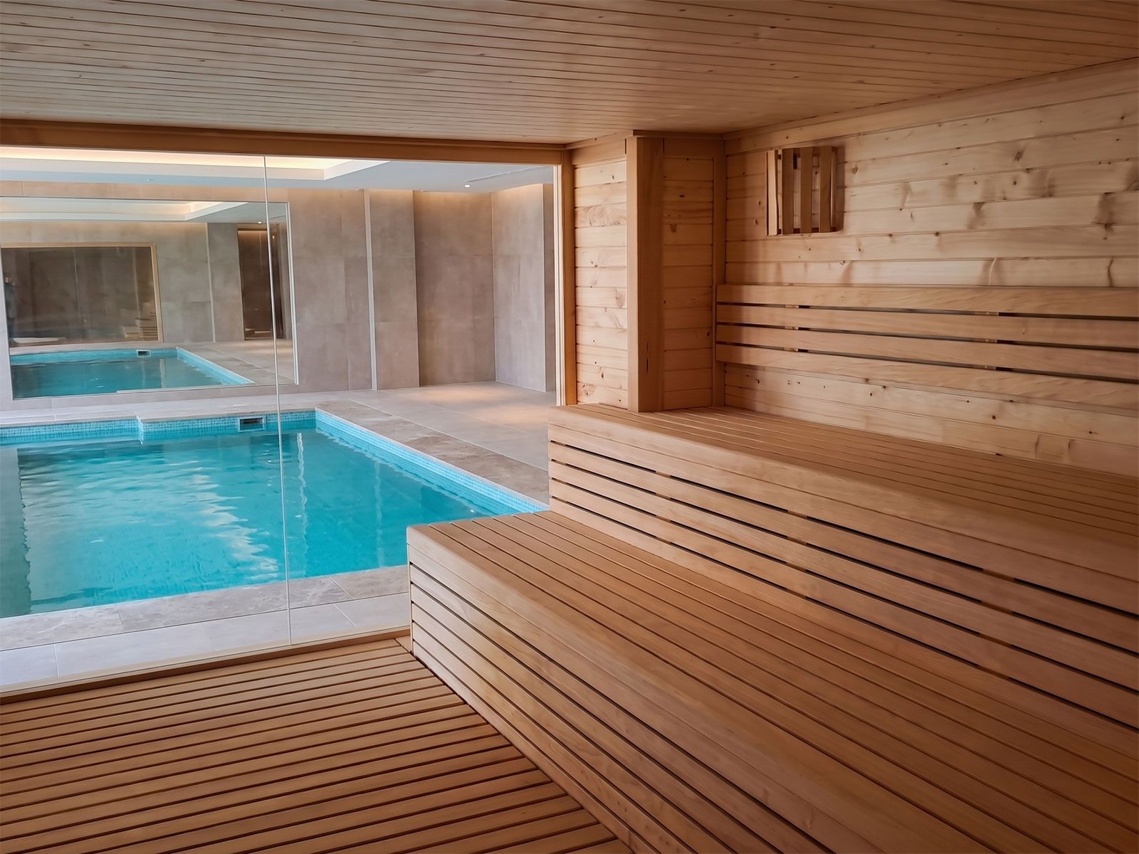 Sauna de interior integrada junto a una piscina